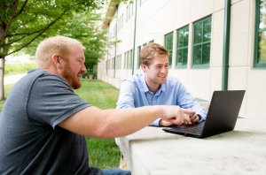 A Cook Medical intern reviews information on a computer screen with his mentor.